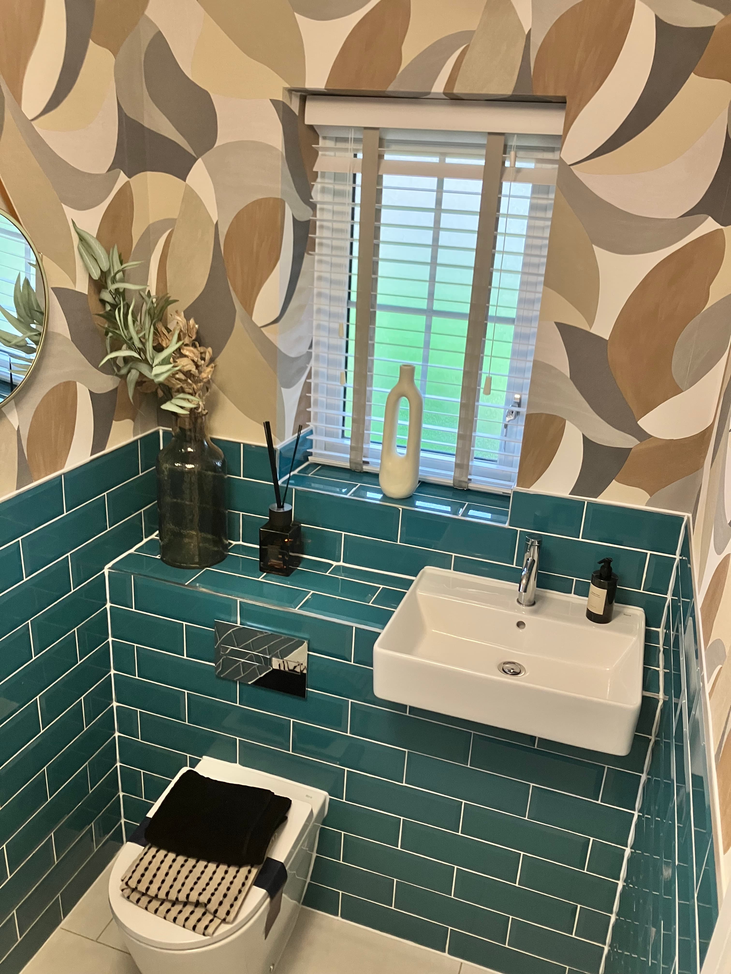 Bath with glass shower screen and round backlit mirror
