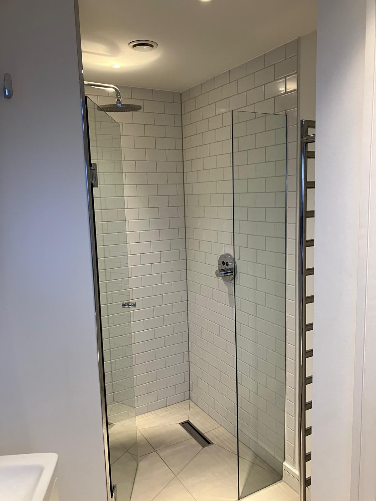 London bathroom refurbishment - heated towel rail and tiled wall