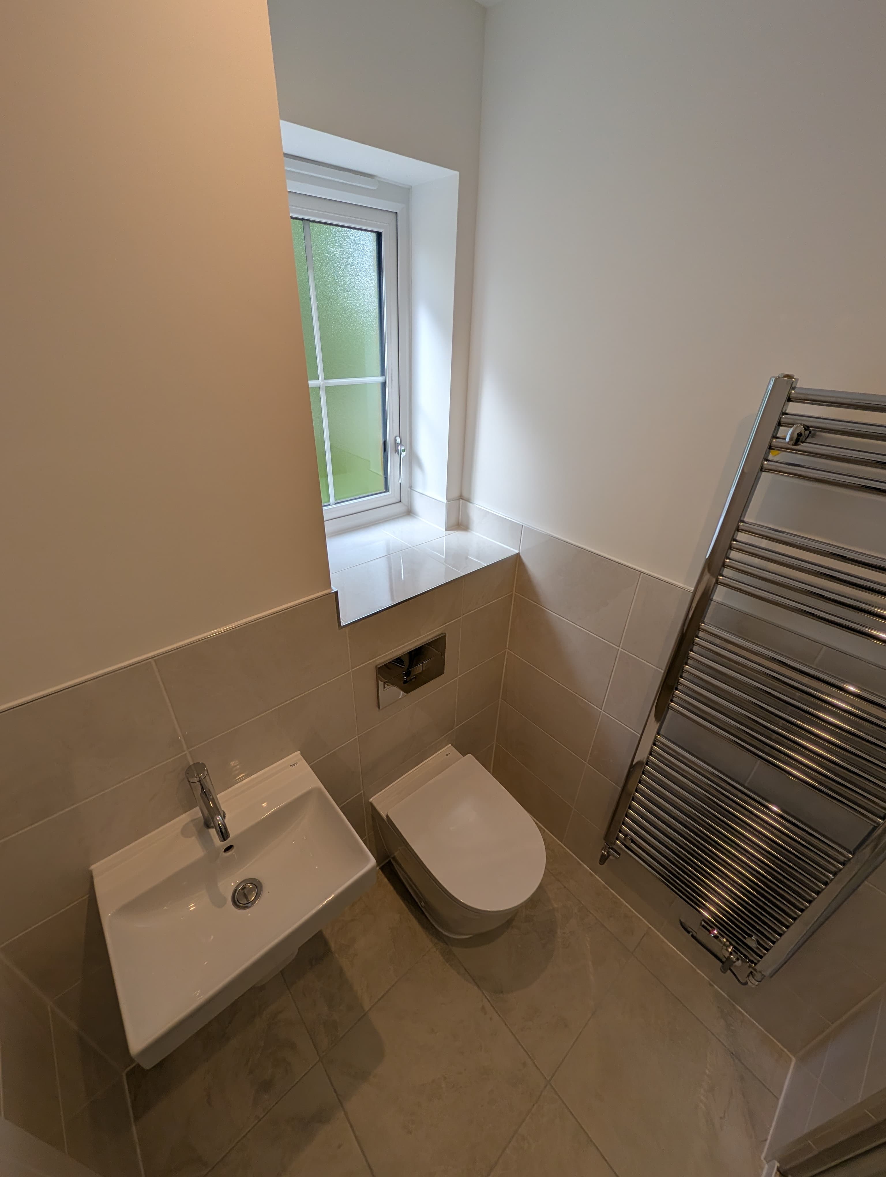 Wall-hung sink, toilet and chrome heated towel rail